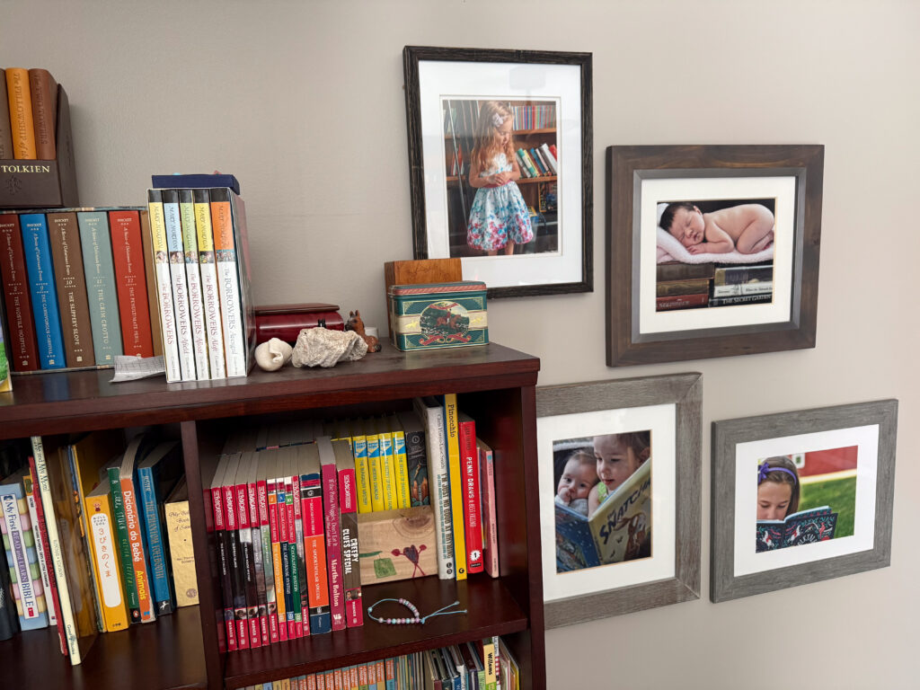 Gallery wall with themed images of children reading next to a bookcase