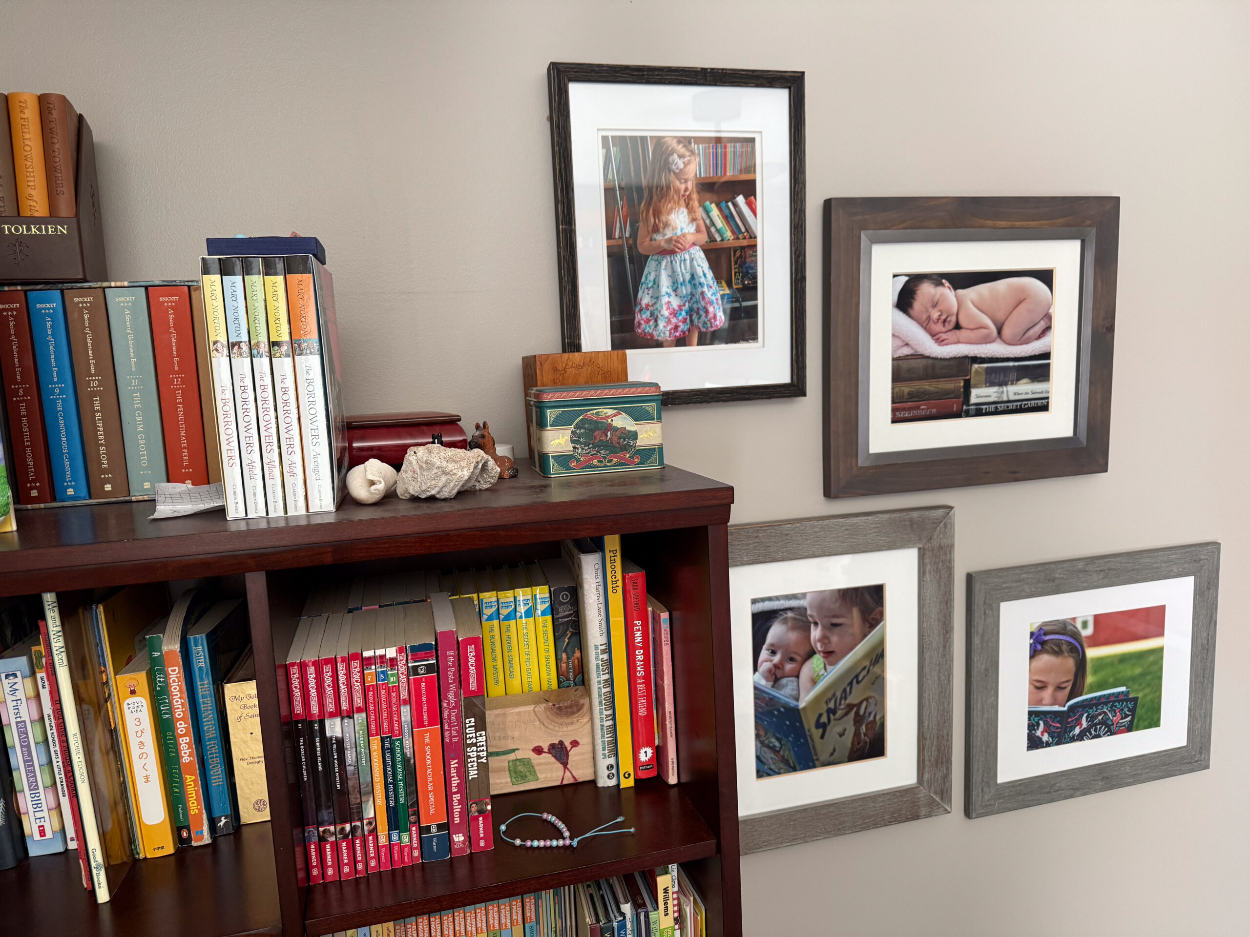 A gallery wall displaying children reading next to a bookcase