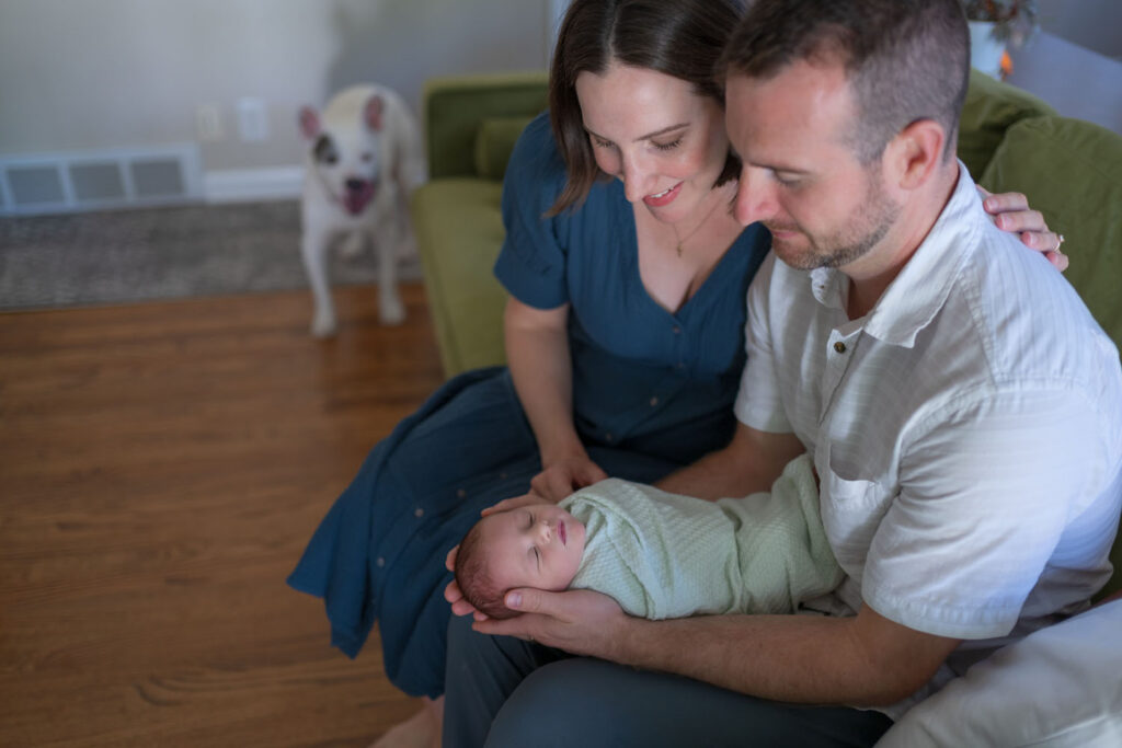 Mother wearing a blue wrap dress during a cozy in-home newborn photography session in Michigan.