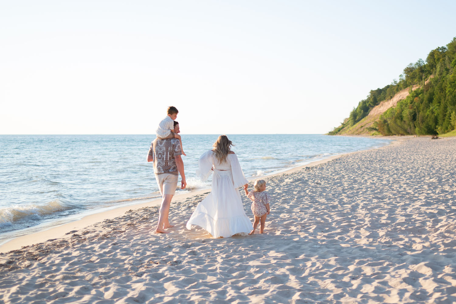 Family along Lake Michigan during Empire Family Photographer session with bluffs in the background