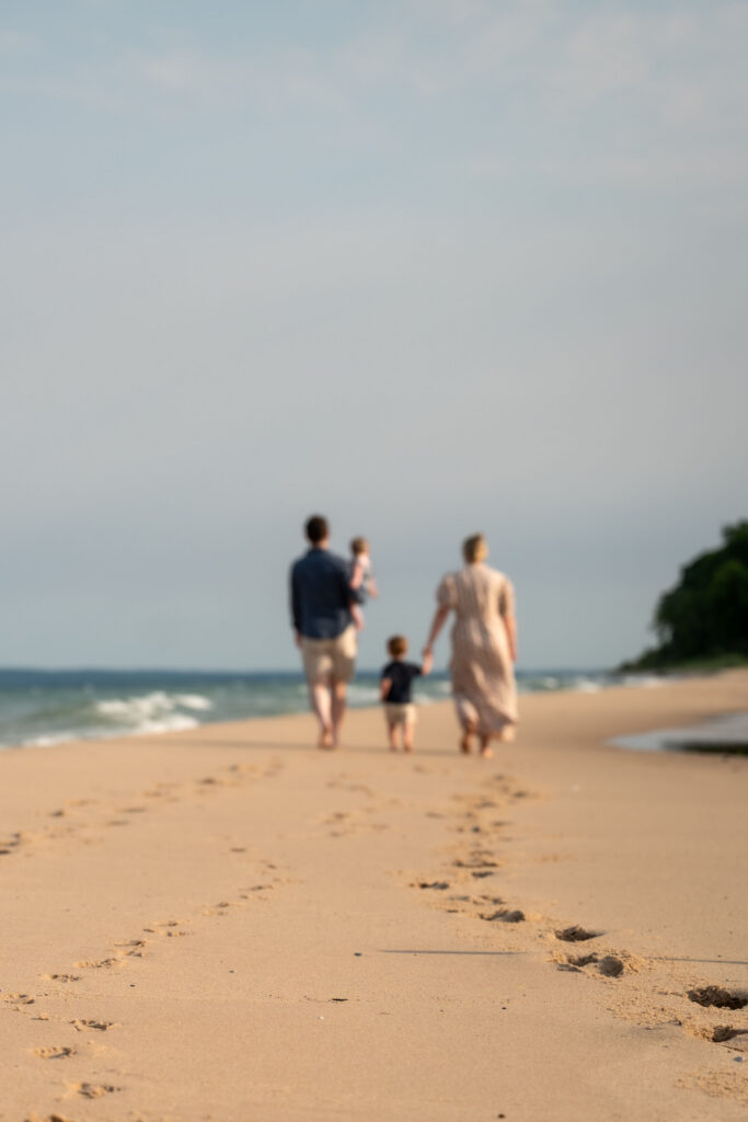 Family leaves footprints in the sand during a family photography session in Empire Michigan