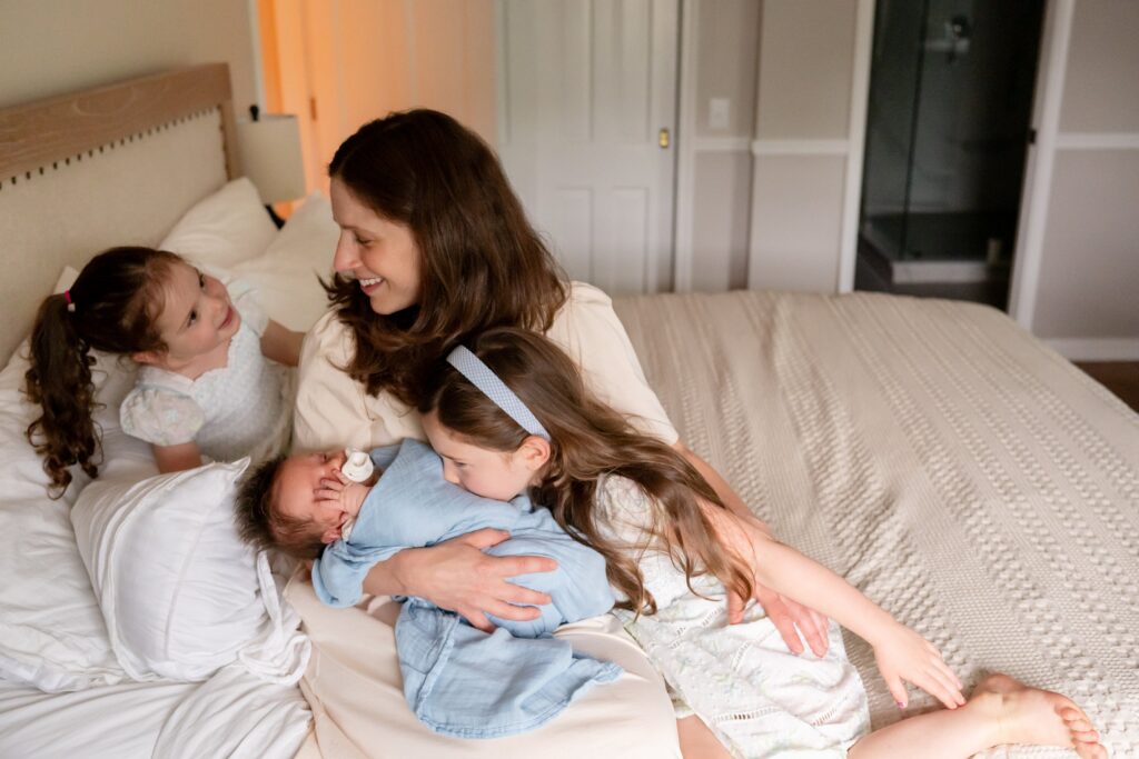 Mom wearing a cream dress for her newborn photo session with toddlers.