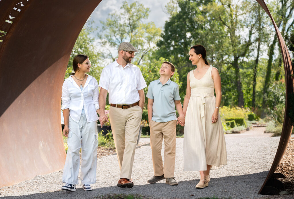 Family of four walking together through Matthaei Botanical gardens